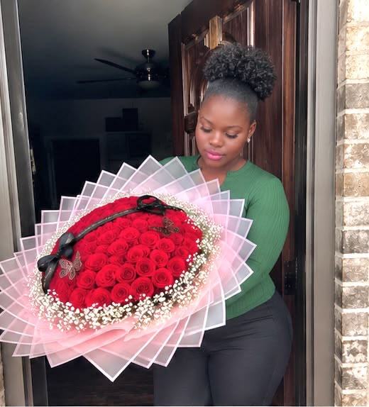Rashida holding a red rose bouquet